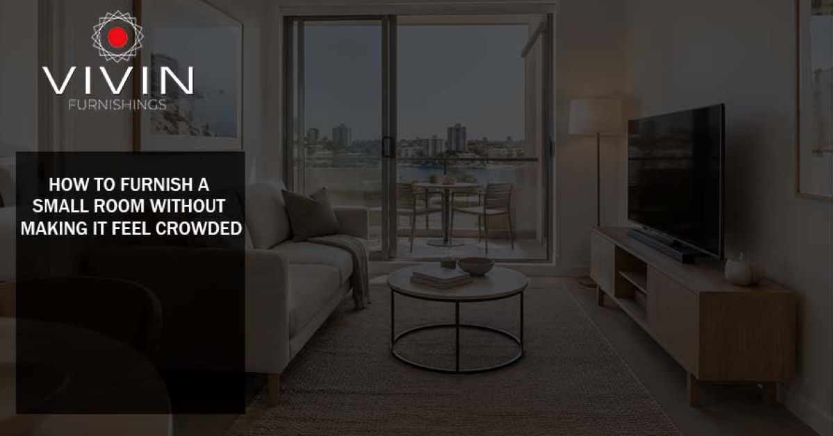 Small modern living room furnished with a neutral sofa, TV unit, coffee table and large window